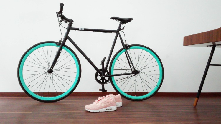 Black bike against white wall with pink sneakers | What Are Daily Habits and How to Build Better Ones