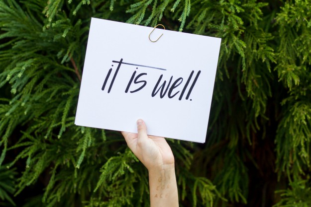 Hand holding sign saying it is well | How to Define Wellness and Make It Work For You