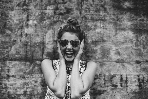 black and white woman happy holding sunglasses | What Productivity Means and How to Get Better at It