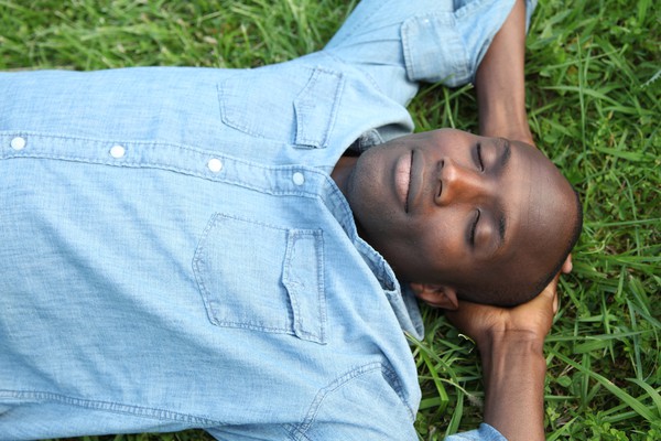 black man blue shirt lying down eyes closed | How to Define Mindfulness and 3 Ways to Try It