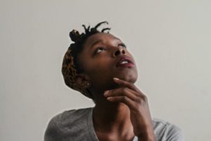 black woman with hands on chin looking up thinking | 5 Steps to Set-Up a Night Routine That Really Works