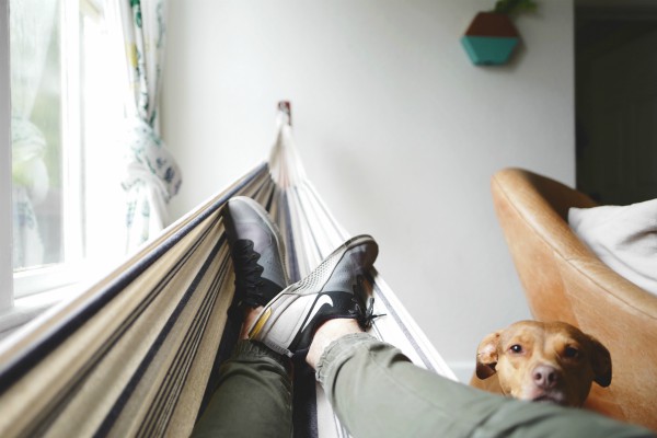 man relaxing with feet in hammock and dog | 5 Steps to a Night Routine That Really Works