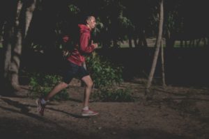 man running outside at night | Have a Happy Holiday by Sticking to Your Fitness Routine