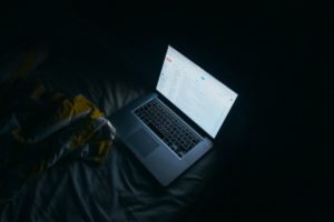 open mac computer in dark room blue light | 5 Steps to Set-Up a Night Routine That Really Works