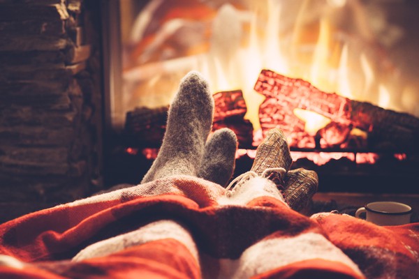 two pairs of feet in front of fireplace relaxing | 5 Steps to a Night Routine That Really Works