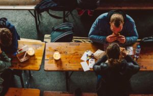 two people eating lunch at wooden table | The Science of Happiness: How to Focus on Friendship