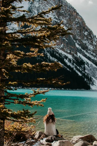 woman in white hat looking at lake and mountains | Got Holiday Stress? This Expert-Backed Tip Can Help