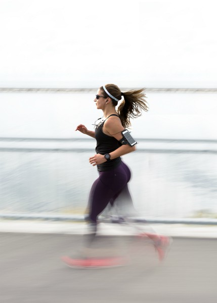 woman running with headphones outside | HIIT for Beginners: The Ultimate Guide to High-Intensity Exercise