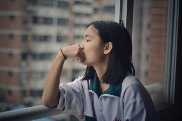 asian woman looking out window pensively | How to Define Gratitude + Have a Better Holiday Season  https://positiveroutines.com/define-gratitude/