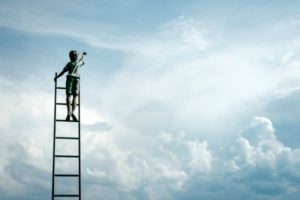 boy on ladder reaching for the sky | 7 Quotes About Goals that Will Keep You Moving