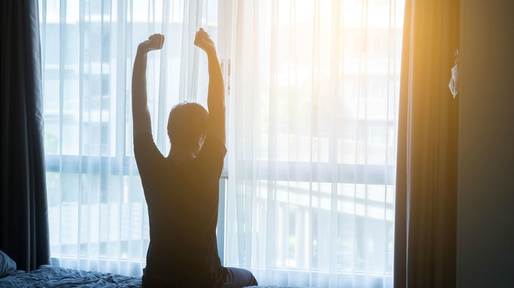 man waking up stretching arms after good night of sleep | This Mediation for Sleep is Key to a Better Night https://positiveroutines.com/meditation-for-sleep-tonight/