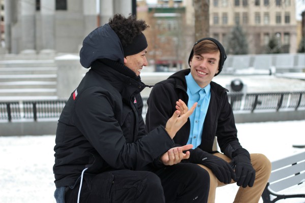 two men sitting on a bench talking outside in winter | 3 Habits of Happy People You Should Borrow