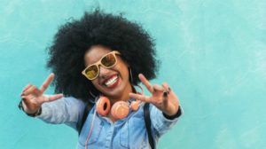 black woman sunglasses holding up peace sign | 54 Ways to Be Happy That Will Crush the Winter Blues