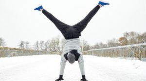 man doing cartwheel outside winter | 54 Ways to Be Happy That Will Crush the Winter Blues