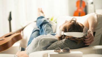 man relaxing on couch with headphones | How to Get Rid of the Sunday Scaries, For Good https://positiveroutines.com/eliminate-sunday-scaries/