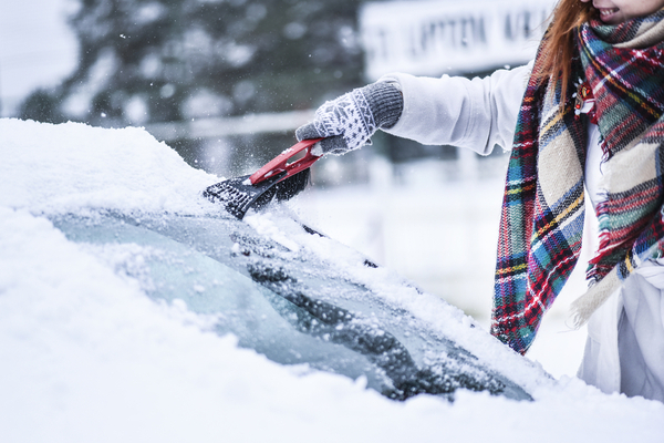 woman scraping snow off windshield in winter | Simple Acts of Kindness to Try This Valentine's Day