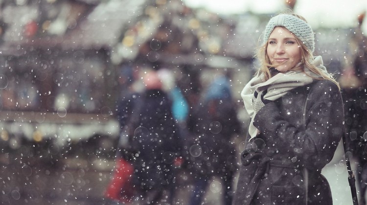 woman standing outside in snow in a city | 54 Ways to Be Happy That Will Reverse the Winter Blues https://positiveroutines.com/ways-to-be-happy/ ‎