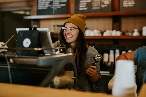 barista with glasses smiling | How to Be Happier This International Day of Happiness
