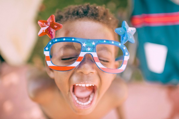 black boy in american flag sunglasses outside happy | Top 5 Insights from World Happiness Report 2018