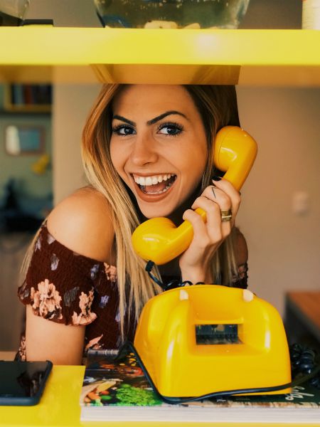 excited woman on yellow phone | Science-Backed Benefits of Forgiveness You Need to Know
