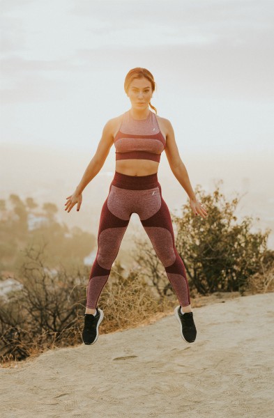 fit woman jumping in air outside | Science-Backed Benefits of Forgiveness You Need to Know