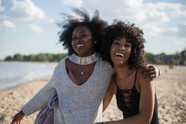 two-black-women-laughing-outside-female-friendships - Positive Routines
