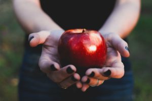 womans hands holding apple | Science-Backed Benefits of Forgiveness You Need to Know