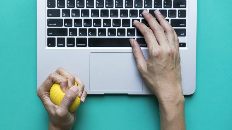 mans hand at laptop squeezing stress ball | Suck at Handling Stress? These Are the 3 Habits You Need https://positiveroutines.com/handling-stress-habits/