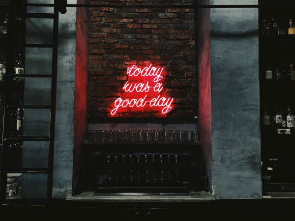 neon sign against brick wall reads today was a good day | How to Be More Positive at Work, According to Science