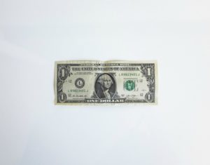 one US dollar on white background | The Research-Backed Guide to Money and Happiness