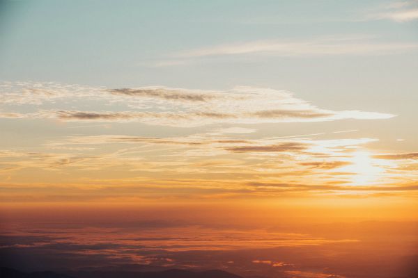 sunrise in clouds | How to Be More Positive at Work, According to Science
