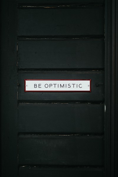 black door with sign be optimistic | Feeling Work Stress? 1 Surprising Way to Get Relief https://positiveroutines.com/work-stress-relief/