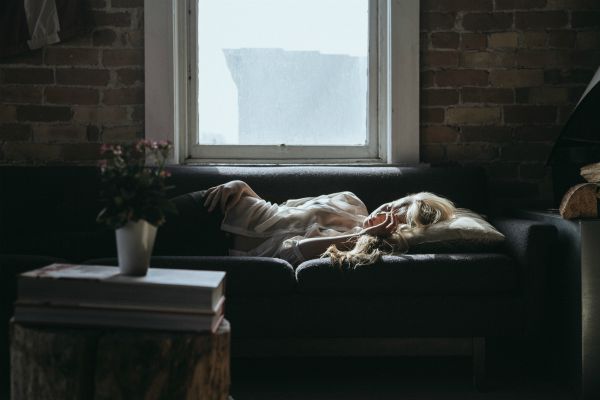 blonde woman asleep on couch | An Adult Bedtime Routine for the Best Sleep Ever https://positiveroutines.com/bedtime-routine-for-adults/