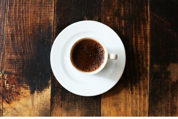 cup of coffee on wooden table | An Adult Bedtime Routine for the Best Sleep Ever https://positiveroutines.com/bedtime-routine-for-adults/