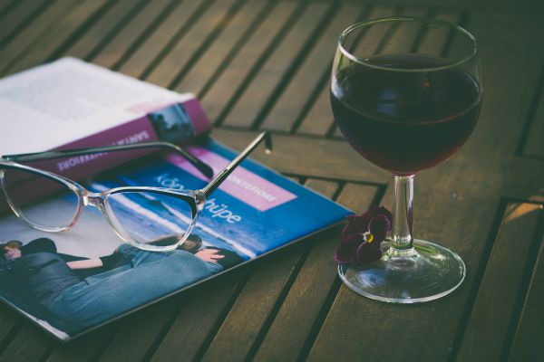 glass of red wine and open book on table | An Adult Bedtime Routine for the Best Sleep Ever https://positiveroutines.com/bedtime-routine-for-adults/