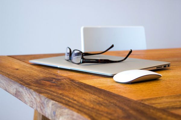 glasses and closed laptop on wooden table | An Adult Bedtime Routine for the Best Sleep Ever https://positiveroutines.com/bedtime-routine-for-adults/
