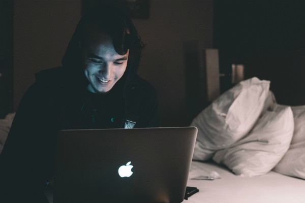 man working on laptop at night in bed | An Adult Bedtime Routine for the Best Sleep Ever https://positiveroutines.com/bedtime-routine-for-adults/