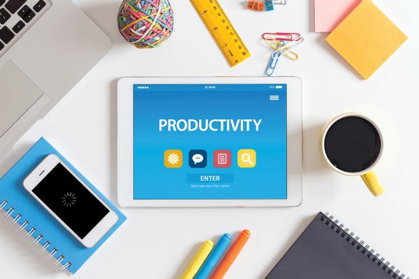 productivity typed on tablet on table with other office tools | 72 Resources to Overcome Procrastination and Improve Productivity https://positiveroutines.com/overcome-procrastination-resources/ 
