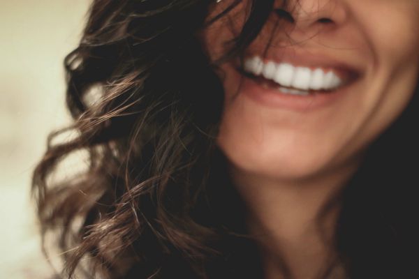 close up of dark haired woman big smile | 3 Expert Secrets to Relationship Building https://positiveroutines.com/relationship-building-secrets/