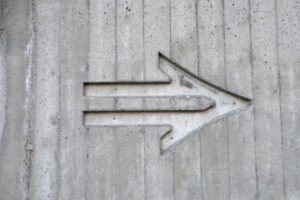 concrete arrow etched into wall | What are SMART Goals + How Do You Set Them? https://positiveroutines.com/what-are-smart-goals/