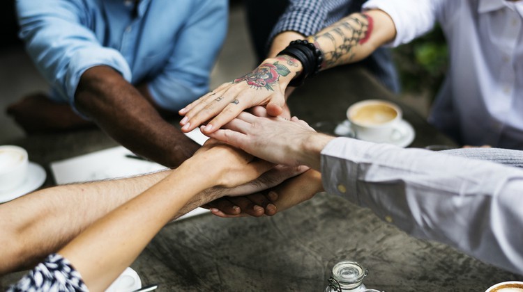 diverse group of hands piled together relationship building concept | 3 Expert Secrets to Relationship Building  https://positiveroutines.com/relationship-building-secrets/