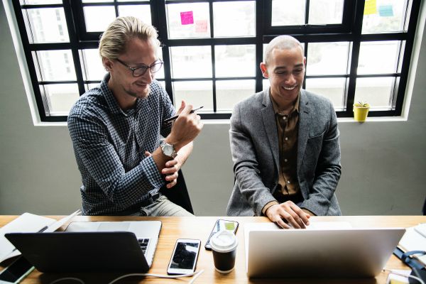 male colleagues collaborating on laptops | 3 Expert Secrets to Relationship Building https://positiveroutines.com/relationship-building-secrets/