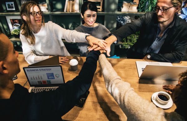 team with all hands in teamwork | Can Staying Positive Increase Your Productivity? https://positiveroutines.com/staying-positive-increase-productivity/