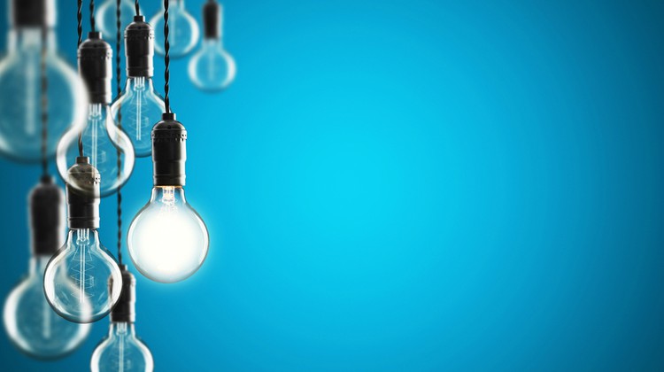 vintage lightbulbs hanging from ceiling one lit up leadership concept | The Best Ted Talks on Leadership to Inspire You Today https://positiveroutines.com/best-ted-talks-leadership/