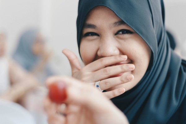 woman in headscarf smiling | Can Staying Positive Increase Your Productivity? https://positiveroutines.com/staying-positive-increase-productivity/