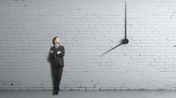 businessman standing near clock on wall time management concept | The Best Time-Management Apps for Better Work-Life Balance https://positiveroutines.com/best-time-management-apps/ 