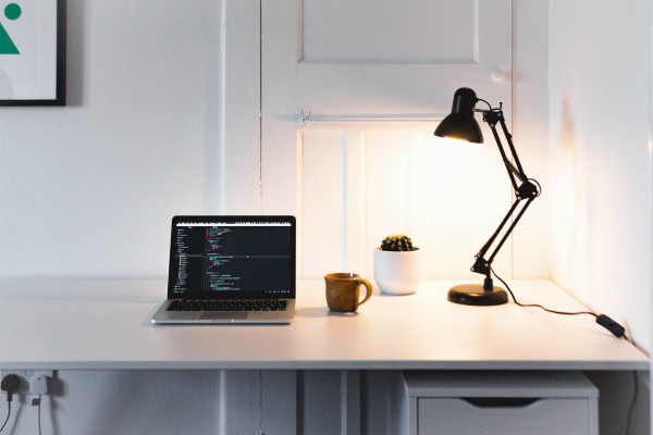 desk with laptop and light | Increase Productivity at Work in This Simple Way  https://positiveroutines.com/increase-productivity-at-work/ 