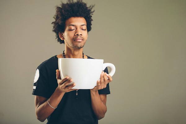 man holding comically large cup of coffee | Can Caffeine Help You Do Something Productive? https://positiveroutines.com/do-something-productive/