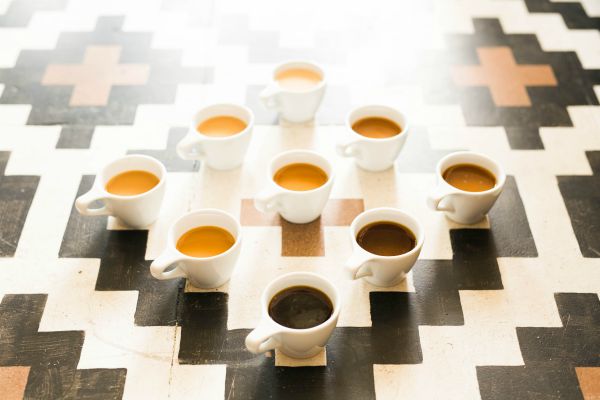 multiple cups of coffee set up in pattern | Can Caffeine Help You Do Something Productive? https://positiveroutines.com/do-something-productive/