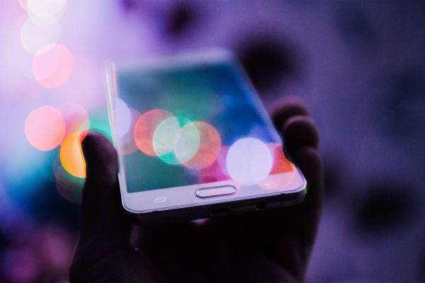 smartphone with colorful bubbles reflected on screen | 75 Great Apps That Will Change Your Life https://positiveroutines.com/great-apps-for-change/ 